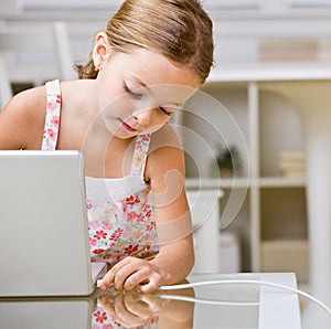 Girl plugging internet cable into laptop photo