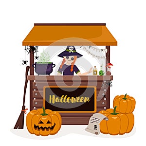 Girl in pointed witch hat at counter of Halloween stall