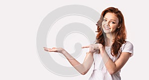 Girl Pointing At Invisible Object On Hand, White Background, Panorama
