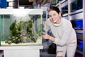 Girl points to an aquarium with barbus