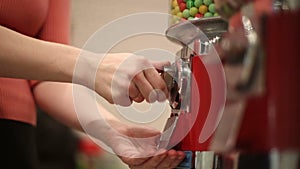 Girl pokes coin in machine sale of sweets