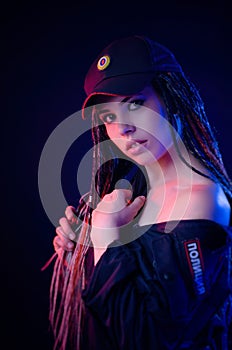 A girl in a police uniform with dreadlocks in neon light with chains and handcuffs English translation the police