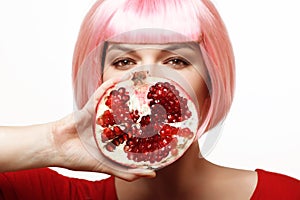 Girl with pomegranate. Pink hair