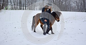 The girl with the poni in the snow photo