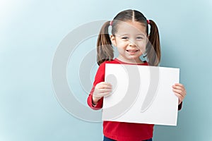 Girl with ponytails and a white sign