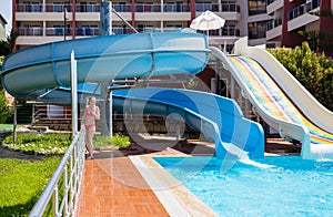 Girl at the pool with slides at resort