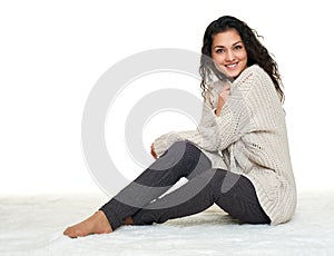 Girl portrait in homelike dress sit on fur floor, white background