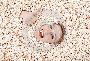 Girl portrait in popcorn. Image of beautiful european woman 20s eating popcorn. Eating popcorn. Young woman buried in