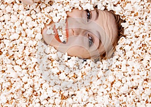 Girl portrait in popcorn. Image of beautiful european woman 20s eating popcorn. Eating popcorn. Young woman buried in