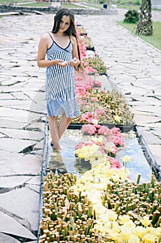 Girl pose in flower bed outdoor, beauty