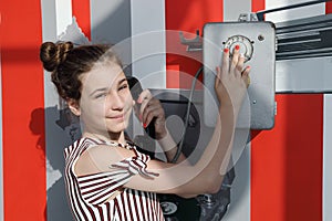 Girl poses with old public phone in soviet museum photo