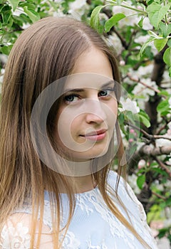 Girl posing against a background of flowering trees