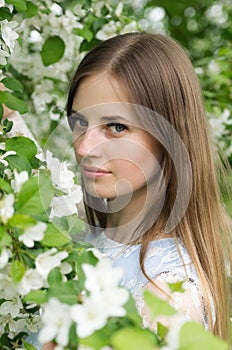 Girl posing against a background of flowering trees