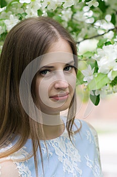 Girl posing against a background of flowering trees