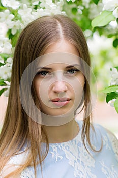 Girl posing against a background of flowering trees