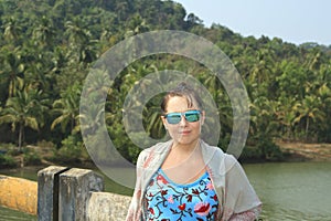 Girl posing on the brige near tropical forest