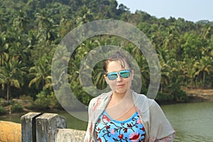 Girl posing on the brige near tropical forest