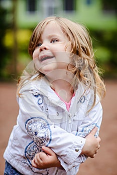 Girl posing at camera holding herself with arms