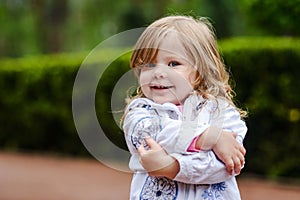 Girl posing at camera holding herself with arms