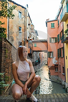 Girl posing. The canal on Via Piella, Bologna, Italy. The old city`s canal which still runs under the town. Travel and tourism photo