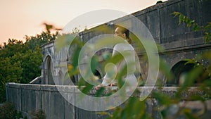 Girl posing castle balcony calm summer evening. Woman leaning on stone railings