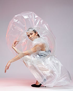 Girl posing in a dress made of plastic film. Fashion portrait