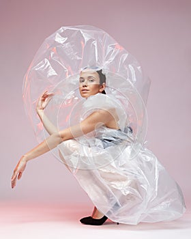 Girl posing in a dress made of plastic film. Fashion portrait