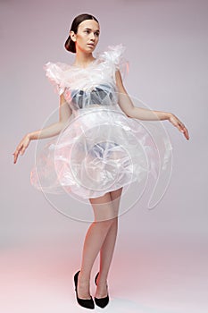 Girl posing in a dress made of plastic film. Fashion portrait