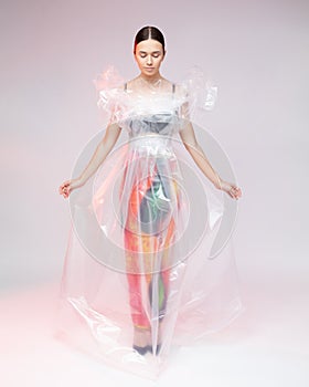 Girl posing in a dress made of plastic film. Fashion portrait