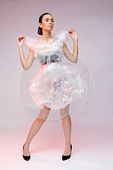 Girl posing in a dress made of plastic film. Fashion portrait