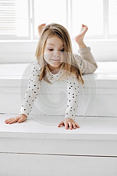 A girl posing in front of a window