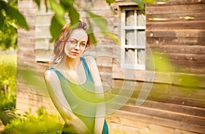 Girl posing in front of a wooden house in the village