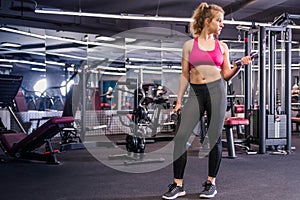 Girl posing in the gym with dumbbell in hand