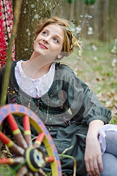 Girl posing near vintage wheel