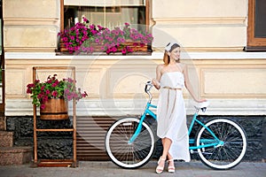 Girl posing at old town with vintage blue retro bicycle