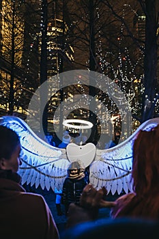 Girl posing for photo in Winter Lights festival in Canary Wharf, London, UK