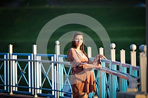 Girl posing on the promenade. A girl walks along the promenade. A young girl walks past the fence