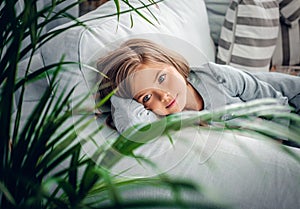 A girl posing on a sofa in a living room.