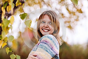 Girl posing under foliage in autumn season