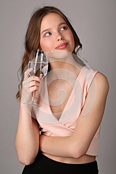 Girl posing with wine glass of water. Close up. Gray background