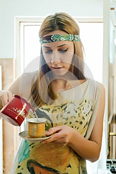 Girl pouring coffee in the kitchen