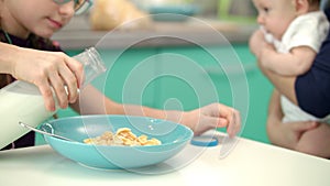 Girl pouring milk into glass bowl of corn flakes. Healthy lifestyle