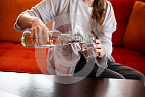 Girl pouring pure water to glass at home