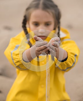 Girl pouring sand from hands