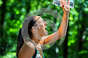 Girl pouring water on face after workout.