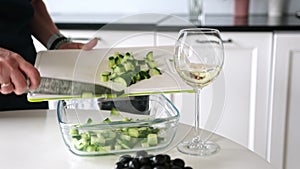 Girl Pours Chopped Cucumbers Into Bowl For Greek Salad