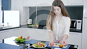 Girl pours olive oil on fresh salad with vegetable in slow motion at kitchen, healthy meal