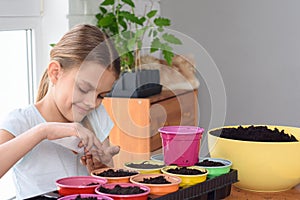 The girl pours seeds from a bag in her hand for further planting