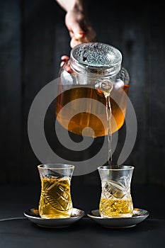 The girl pours tea in an armud