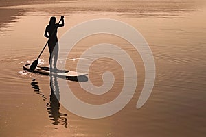 Girl practices stand up paddling